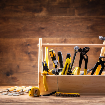 a bunch of hand tools on a wooden box and wooden background